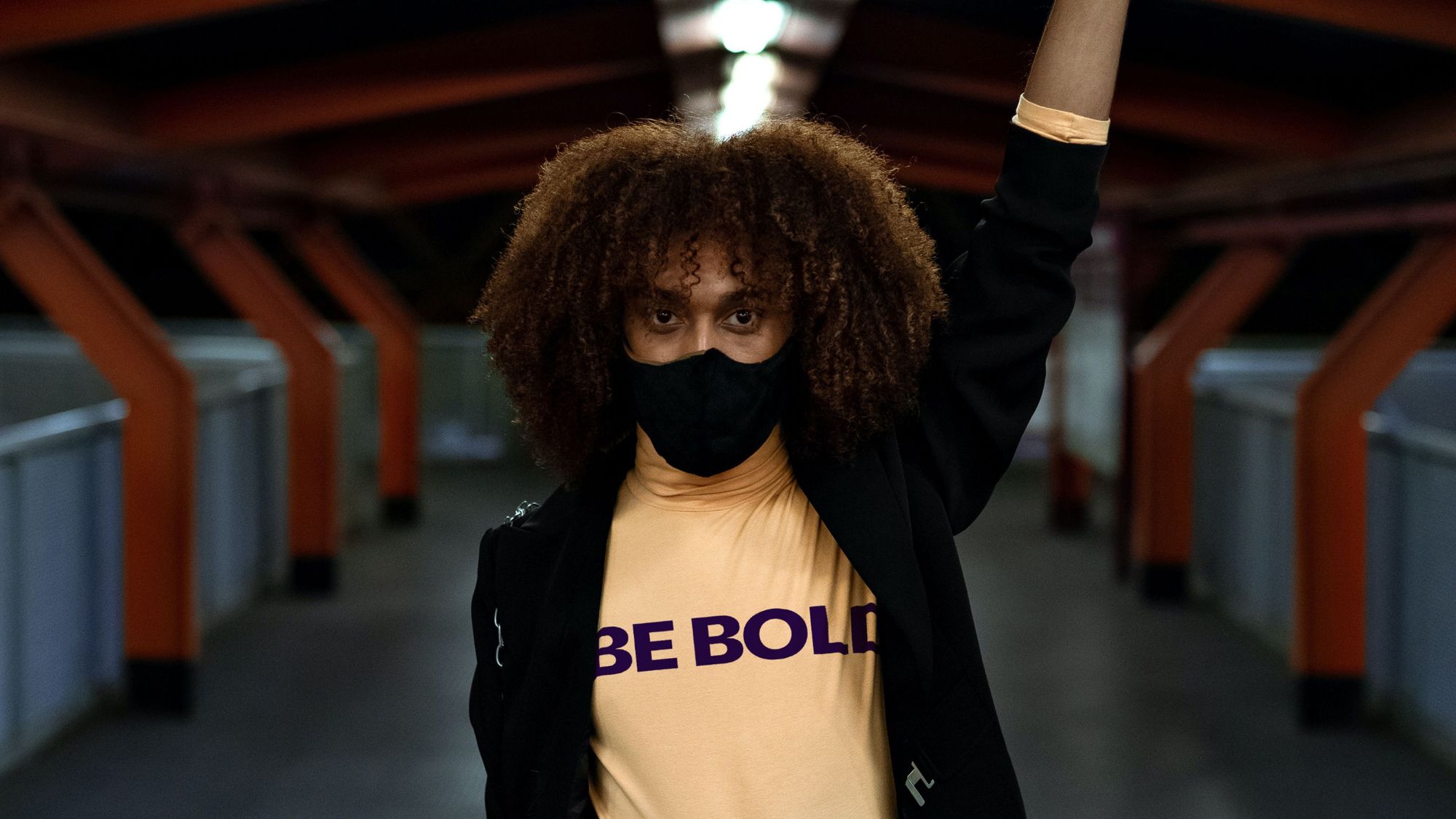 Woman raising her arm with Be Bold Media on her t-shirt